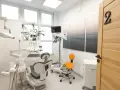 Nowoczesny gabinet stomatologiczny z fotelem, mikroskopem i drzwiami z numerem 2.
