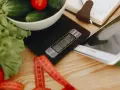 Waga kuchenna, miarka i tablet – narzędzia do planowania diety i obliczenia zapotrzebowania kalorycznego.