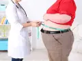 Lekarz obesitolog mierzy obwód talii pacjenta.