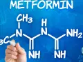 Struktura metforminy i jej potencjalne metformina skutki uboczne. Ręka pisze wzór chemiczny na niebieskim tle.