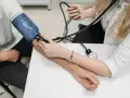 Lekarz mierzy ciśnienie krwi pacjentowi za pomocą ciśnieniomierza.