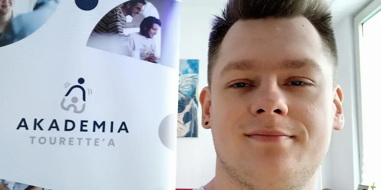 Mężczyzna z tatuażem na uchu obok logo "Akademia Tourette'a".