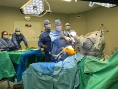Zespół chirurgów w sali operacyjnej podczas zabiegu ortopedycznego z użyciem robota.