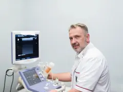 Ortopeda w białym fartuchu przy aparacie USG.