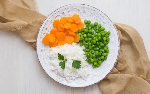 Talerz z ryżem, marchewką i groszkiem, idealny na dietę lekkostrawną.