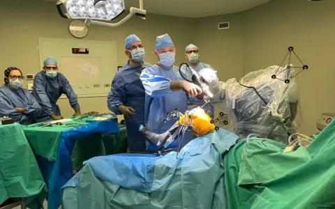 Zespół chirurgów w sali operacyjnej podczas zabiegu ortopedycznego z użyciem robota.