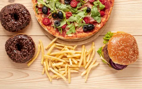 Pizza, burger, frytki i pączki z czekoladą – uczta pełna tłuszczów nasyconych.