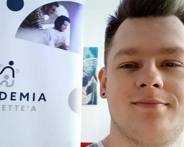 Mężczyzna z tatuażem na uchu obok logo "Akademia Tourette'a".