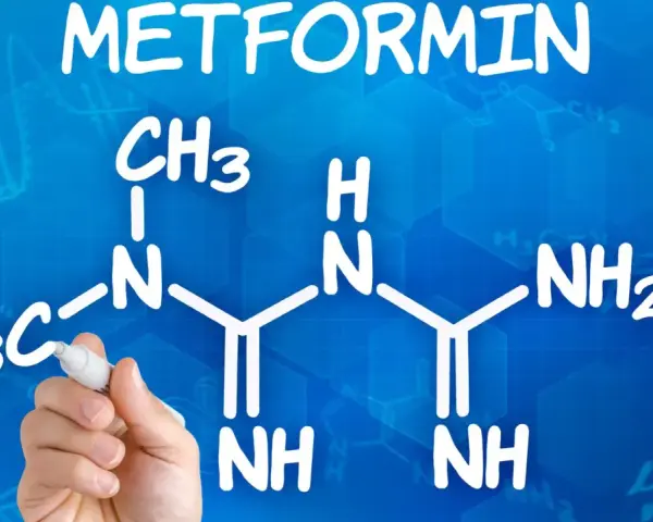 Struktura metforminy i jej potencjalne metformina skutki uboczne. Ręka pisze wzór chemiczny na niebieskim tle.