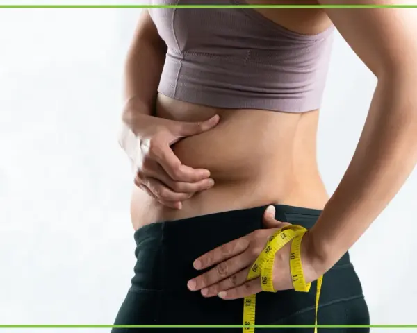 Osoba z obfitym brzuchem, mimo szczupłej sylwetki, mierzy talię. To przykład tzw. "skinny fat".
