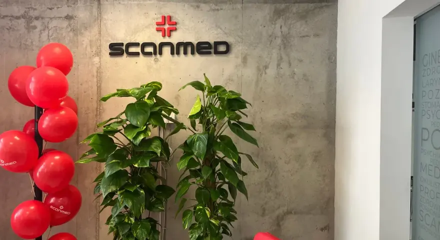 Czerwone balony, logo Scanmed i rośliny w nowoczesnym wnętrzu kliniki medycznej.
