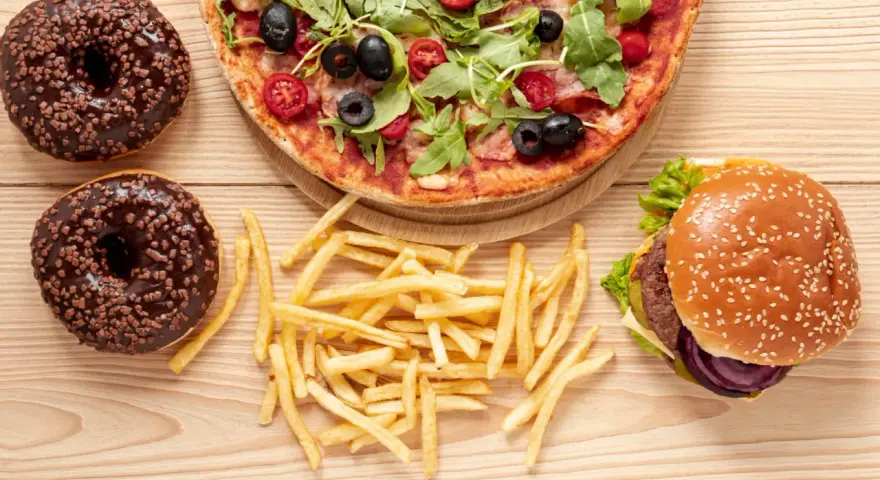 Pizza, burger, frytki i pączki z czekoladą – uczta pełna tłuszczów nasyconych.